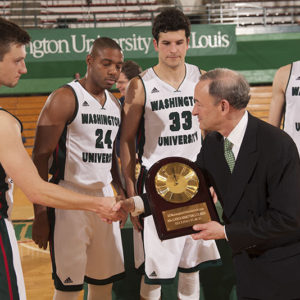 basketball players accept trophy