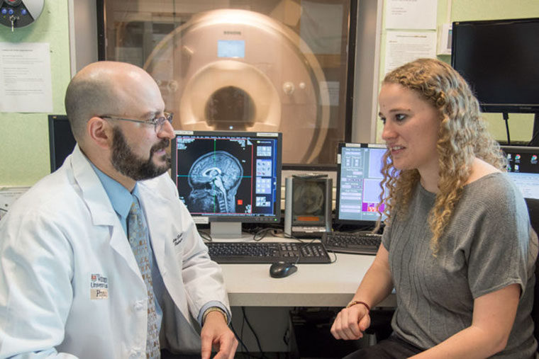 Bradley Schlaggar discusses a brain scan with a student