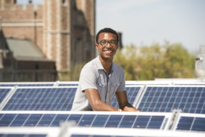 Deko Ricketts, BS '17, among the solar panels on the top of Hillman Hall.