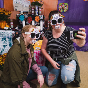 students take a selfie by Halloween display