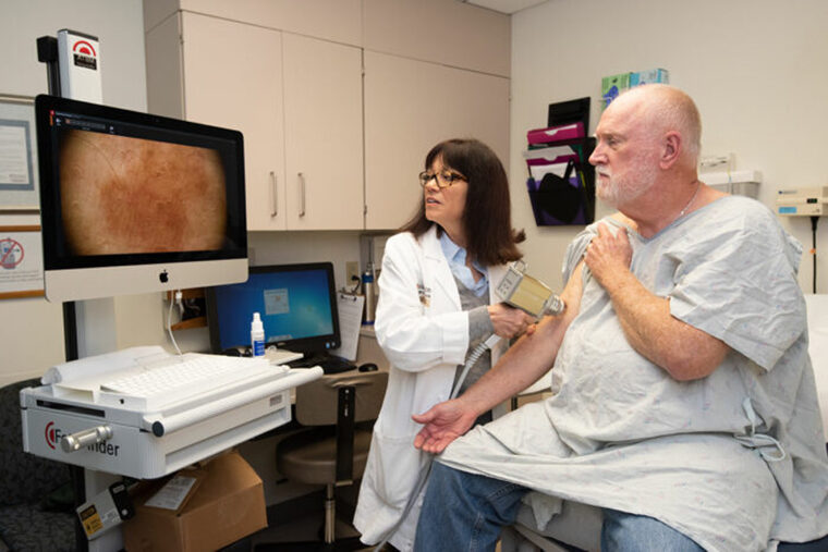 dermatologist conducts skin exam on patient