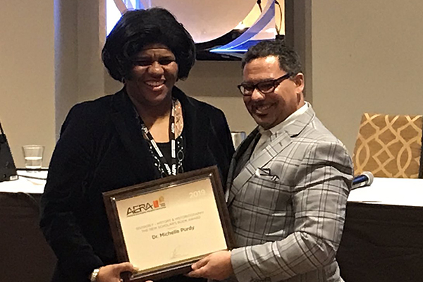 Michelle Purdy receives the 2019 AERA book award from Christopher Span, vice president of AERA’s Division F and associate professor of education at the University of Illinois-Champaign Urbana.