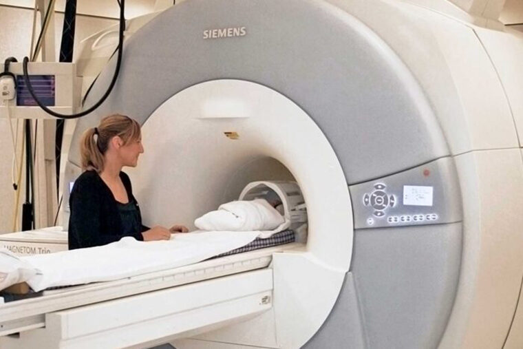 A mother watches as her sleeping baby undergoes an MRI brain scan. Researchers at Washington University School of Medicine in St. Louis are leading a multicenter team conducting research to evaluate whether brain imaging might help reveal risk for autism spectrum disorder in early infancy. Previous research suggests such imaging in high-risk children can predict problems in kids as young as 6 months old.