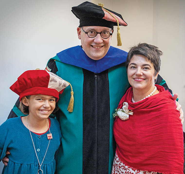 Chancellor Martin, his wife, Stephanie, and their daughter, Olive, share a relaxed moment while robing for the inauguration ceremony. Chancellor Martin and Olive are wearing custom tams (the distinctive head covering typically seen as part of academic regalia) designed by senior Meredith Liu, a fashion design major in the Sam Fox School of Design & Visual Arts. Liu. (Photo: Joe Angeles/Washington University)