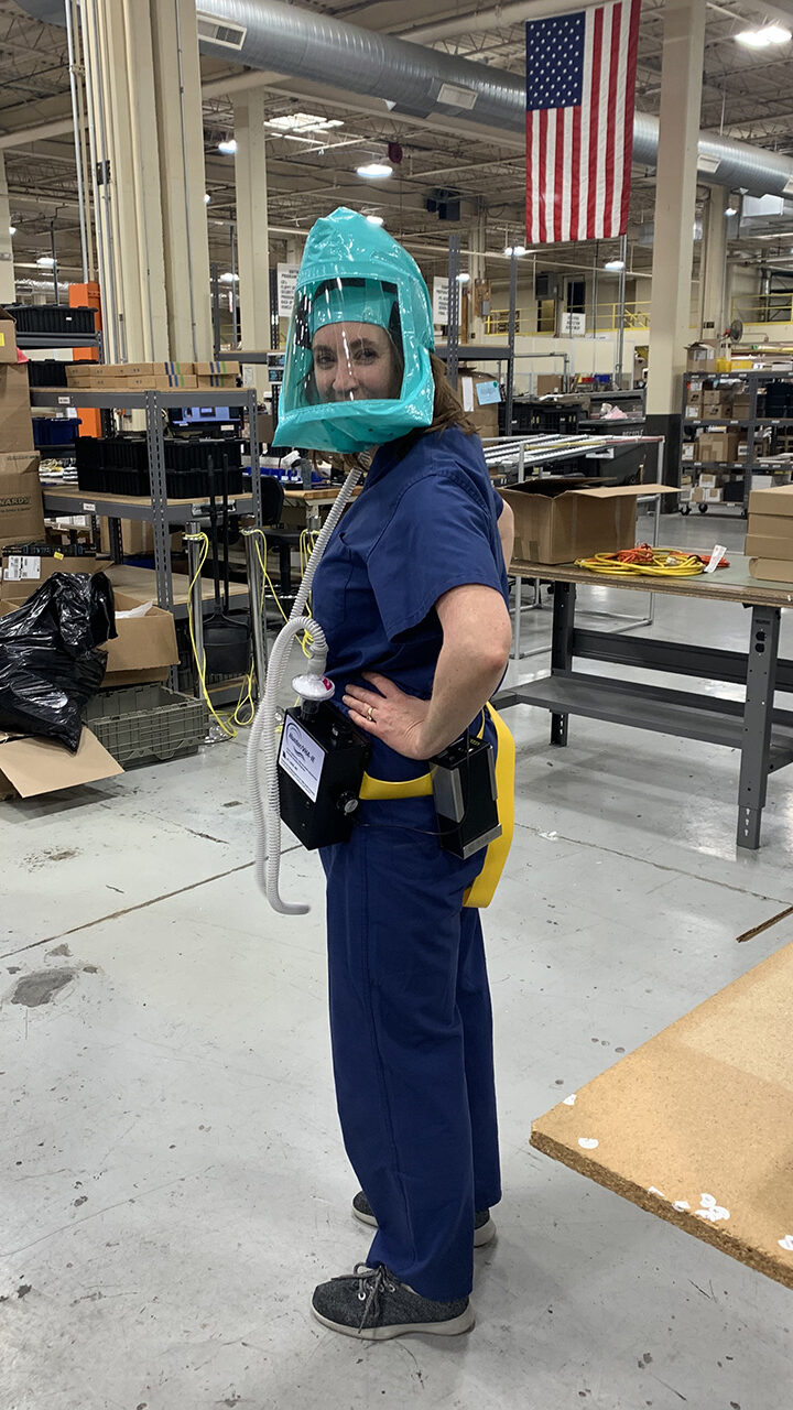 Jennifer DeLaney, MD ’97, models version 2 of the powered air-purifying respirator at Hunter Engineering, which provided numerous volunteer hours to help DeLaney develop and build the prototype and manufacture the units. (Courtesy photo)