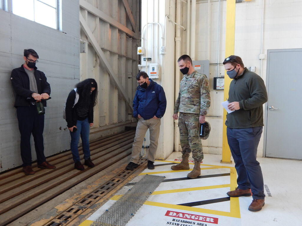 Washington University graduate students (left to right) Kyle Collier, Astha Bhatnagar, and Cam Loyet talk with 375th Civil Engineer Squadron’s Kenneth Cavanaugh (middle) and squadron commander Lt. Col. Paul Fredin about water drainage inside Hangar 3. On Aug. 12, 2020, over five inches of rain fell within two hours on Scott Air Force Base causing damage to several buildings including the hangar. The students discussed several potential solutions to prevent future flooding inside the hangar. (Photo: Courtesy of Christine Spargur)