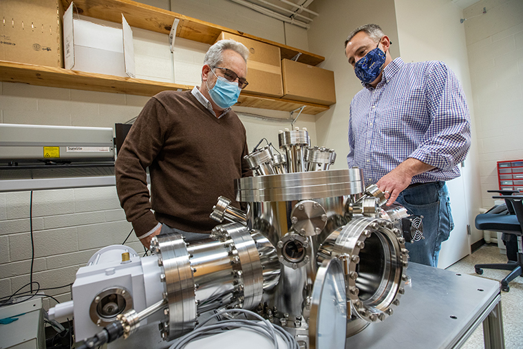 Kevin McKeegan (left) returned to WashU in November 2021 to deliver the Robert M. Walker Distinguished Lecture. But before he did, he spent some time on the Danforth Campus, including a visit to the Space Weathering Lab of Jeff Gillis-Davis in Compton Hall.