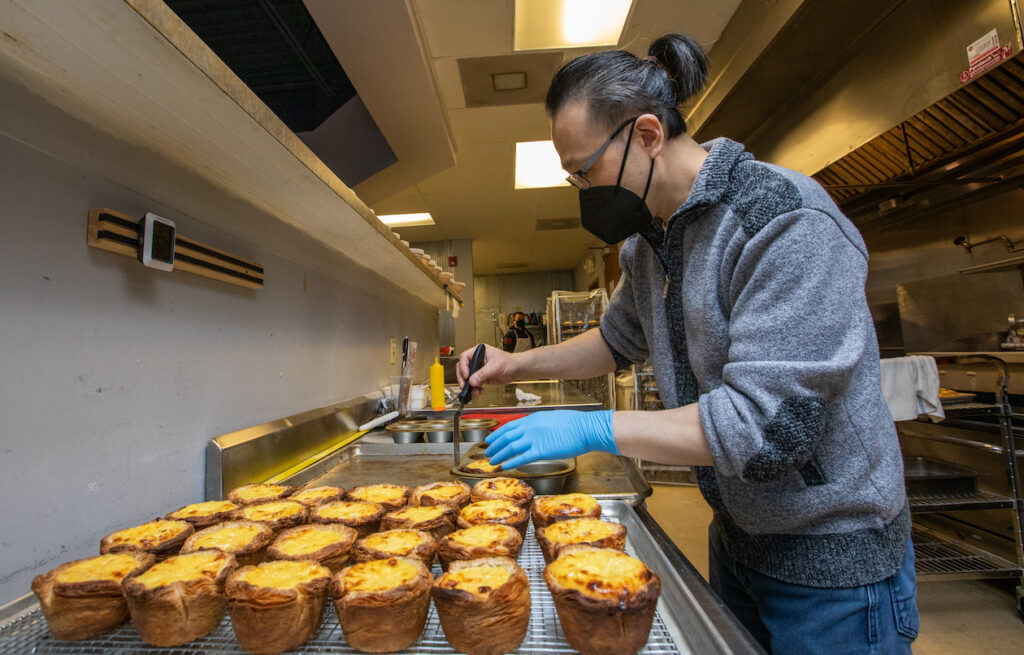 Raymond Yeh removes Baked Pasteis De Nata (Known as the Portugese egg tart) from their muffin pan.