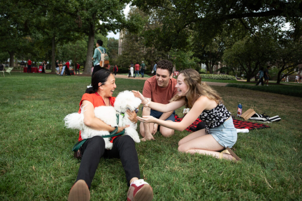 Anna Gonzalez, vice chancellor for student affairs, and her dog, Yoshi, hang out with students