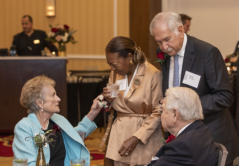 Peggy Newman, AB ’72, JD ’76, and Trustee Andy Newman, (standing) recipients of the Robert S. Brookings Award, visit with Carol Bauer and George P. Bauer, BS ’53, MS ’59, who received the Distinguished Alumni Award at the university's Founders Day Ceremony.
