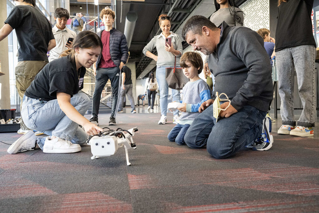 Attendees interact with a robot