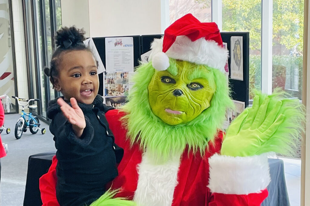 The Grinch poses with a child