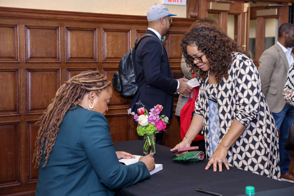 Heather McGhee signs book for attendee