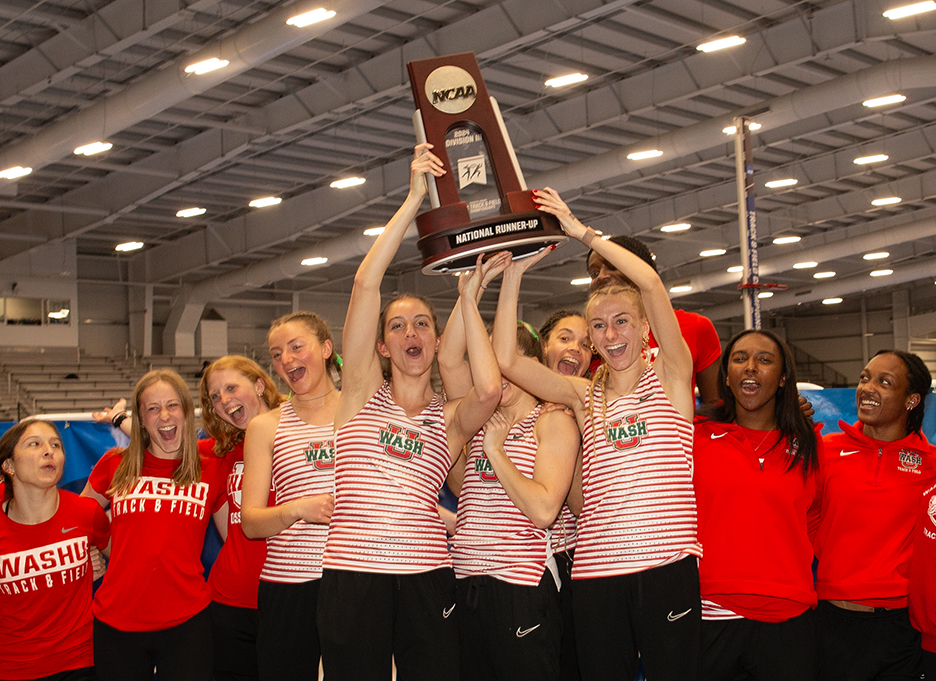 Women's track team celebrates with trophy