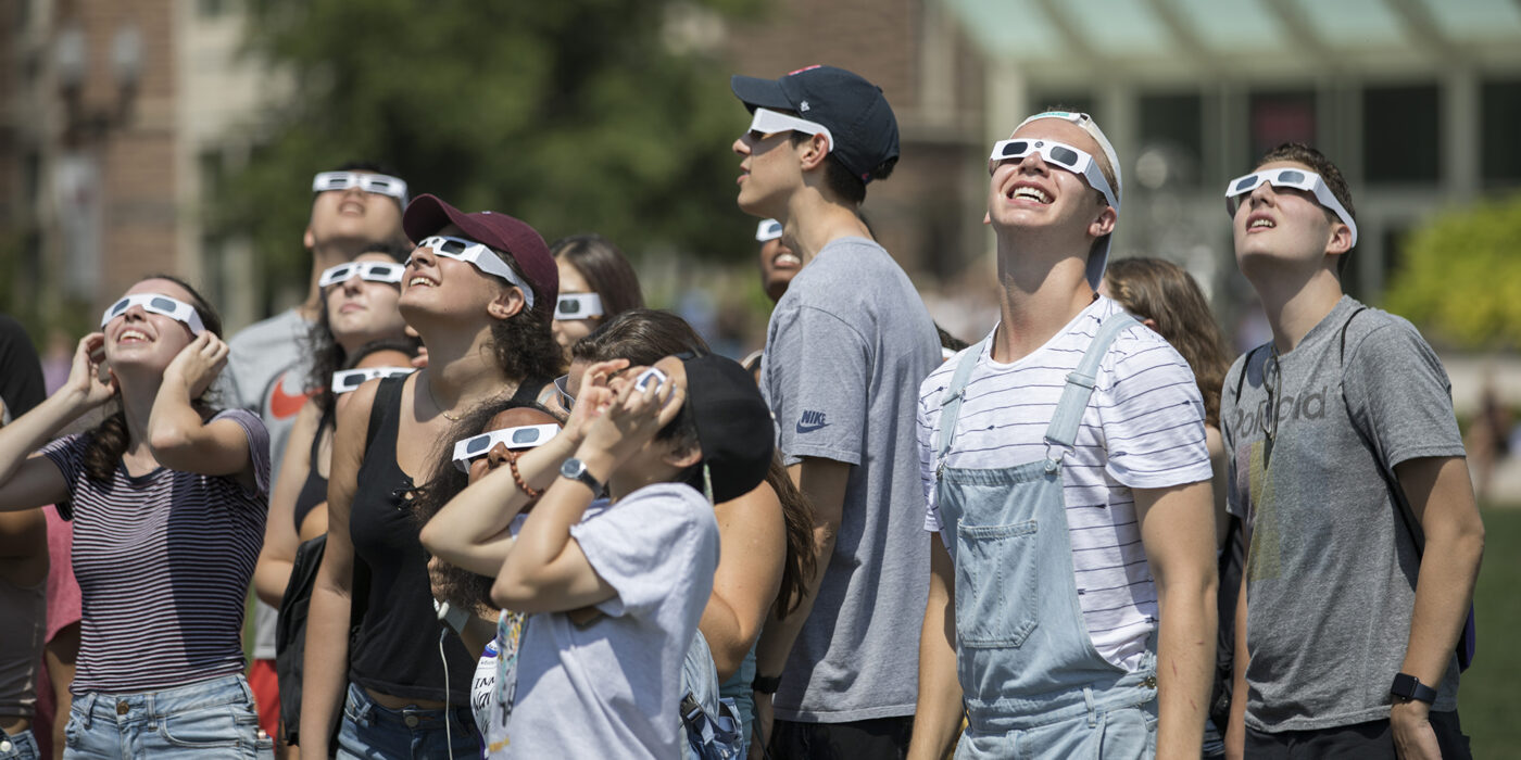 WashU students wearing glasses looking up at 2017 solar eclipse