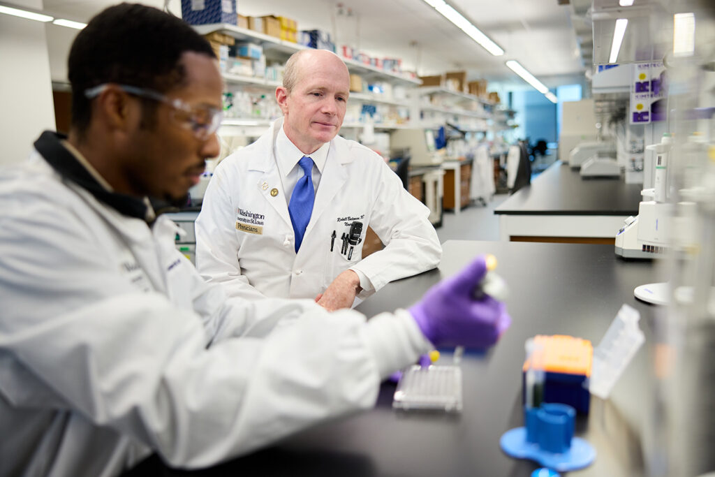 Randall Bateman, MD (right), director of the Dominantly Inherited Alzheimer Network (DIAN) and founding director of the DIAN-Trials Unit (DIAN-TU), confers with research technician Olatayo Ajenifuja. In his lab in the Jeffrey T. Fort Neuroscience Research Building, Bateman trains junior faculty, postdoctoral fellows, graduate students and undergraduates as they investigate the causes and methods of diagnosis and treatment of Alzheimer’s disease by using a wide variety of assays and techniques. (Photo: Matt Miller/Washington University School of Medicine)