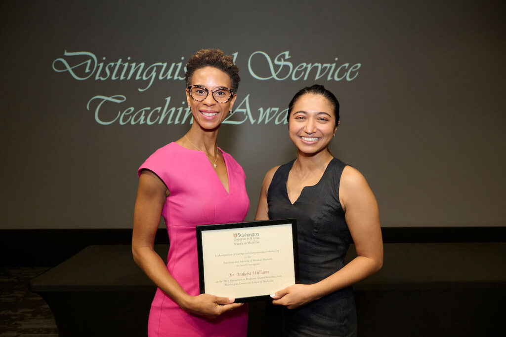 Makeba Williams, MD (left), an associate professor at the School of Medicine, accepts the Humanism in Medicine award from medical student Isabella Gomes